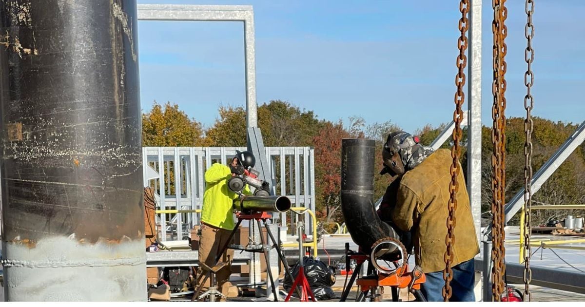 Techs outside a site working on plumbing